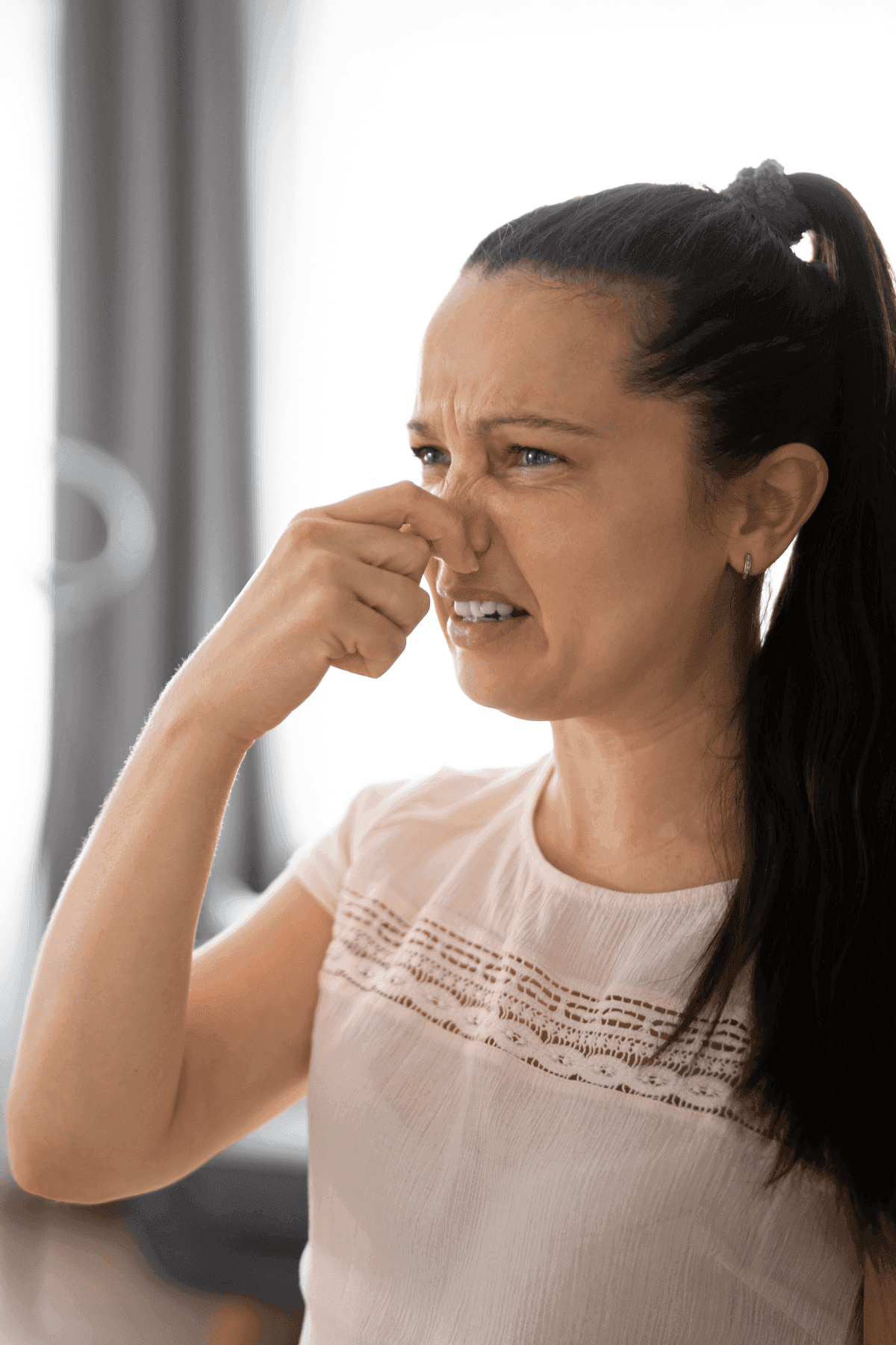 Woman holding her nose because of a bad smell